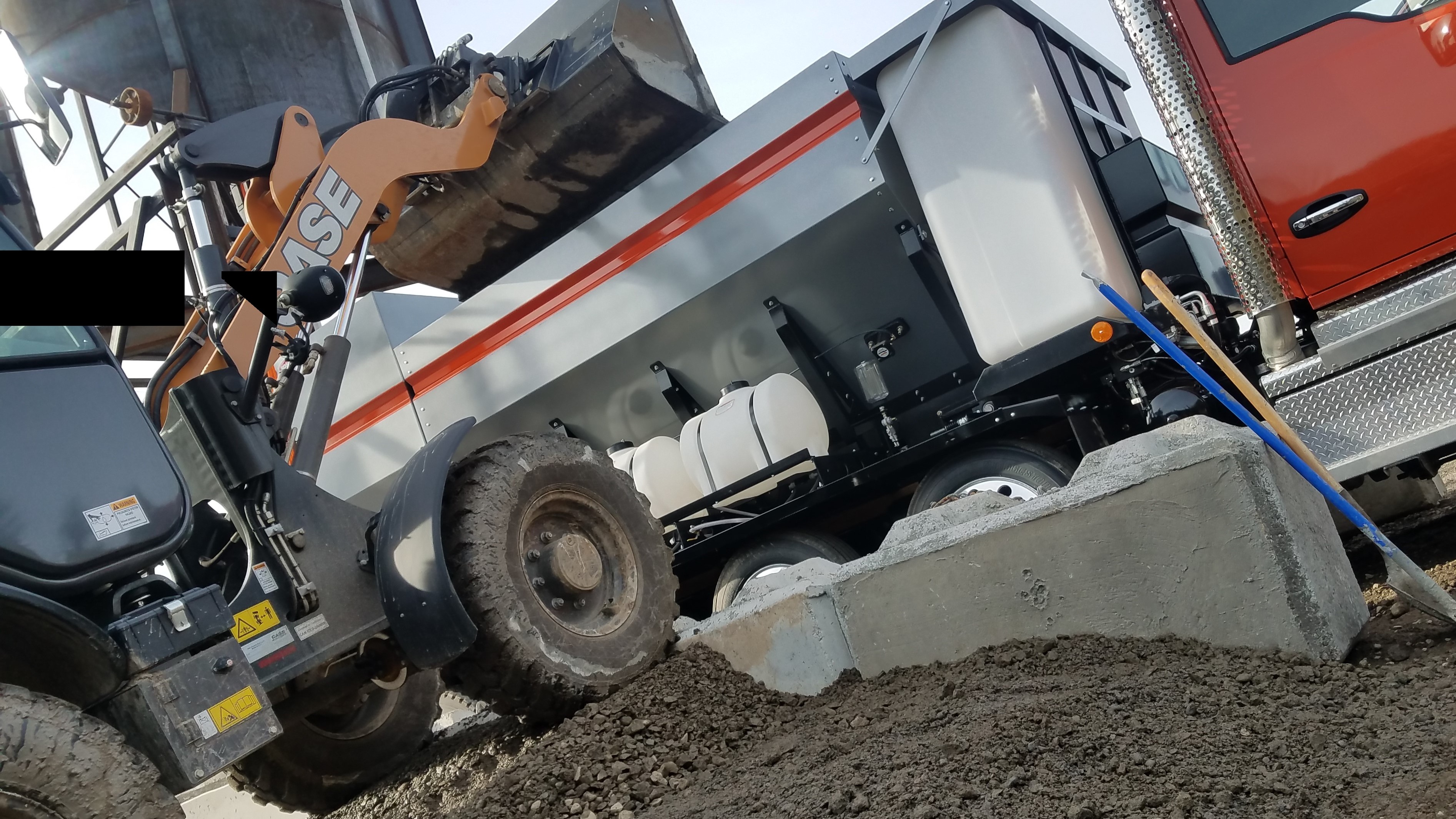 Loading sand, cement, and river rock along with hot water into the Roadmaster